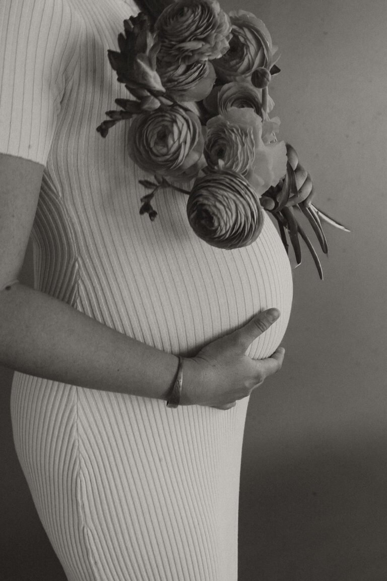 Schwangerschaftsfotografie im Kleid mit Blumenstraß, aufgenommen im Fotostudio von Laura Rahm